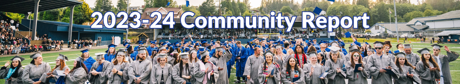 GHC graduates stand for the graduation ceremony with a sense of cheer. GED students are up front in gray robes and cap with the College graduates behind them in blue.